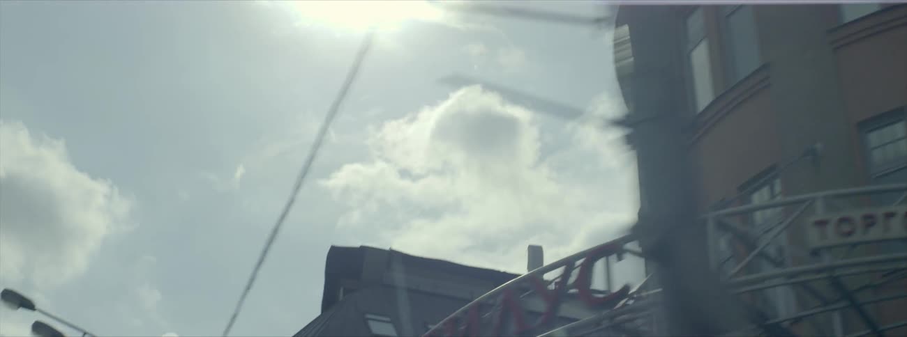 The sun shines on building rooftops and telephone wires