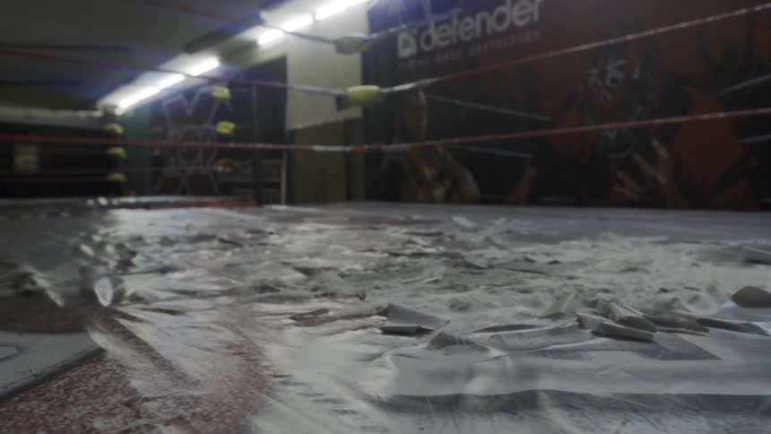 The torn up floor of a wrestling ring is shown