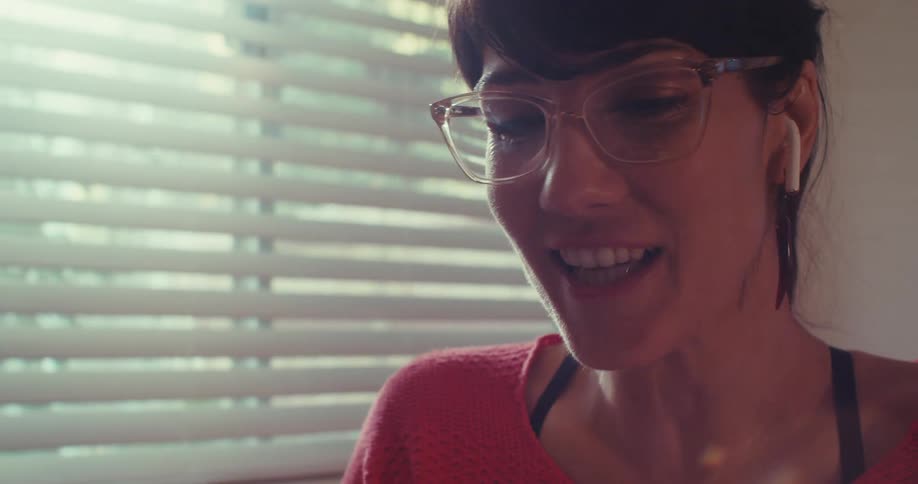 Girl wearing earbuds laughs while she talks