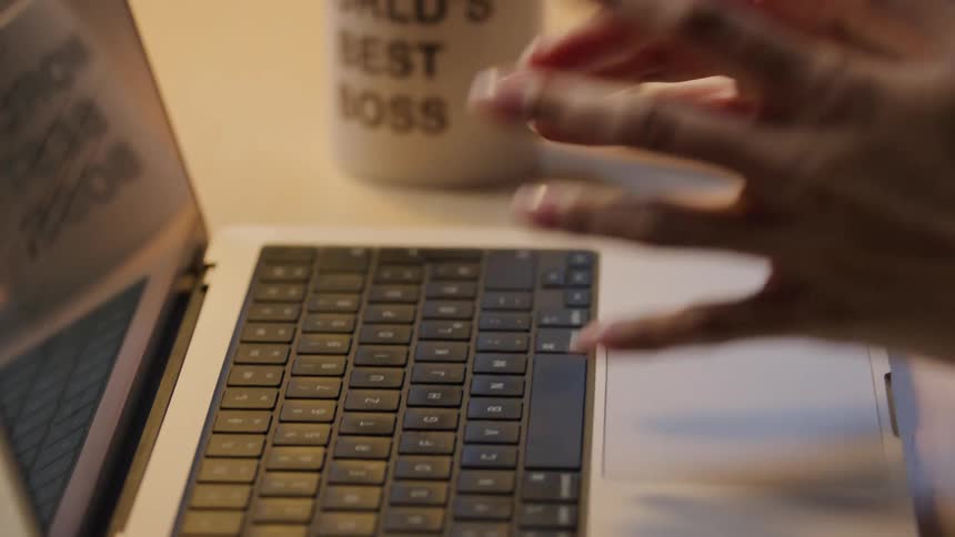 Lady stretches her hands after typing on a laptop