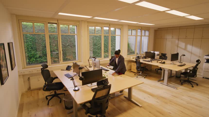 Man arrives at office and sits at desk to start work