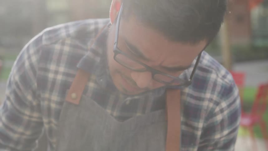 A man wearing glasses is working outdoors