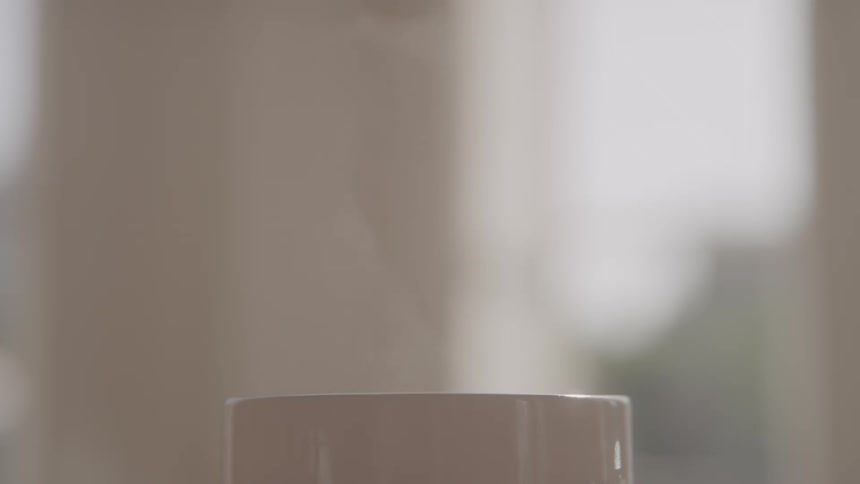 Steam rising from a white porcelain coffee mug