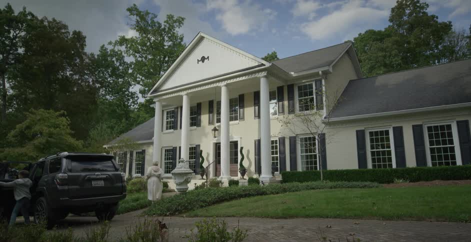 Pickup truck parking in front of a mansion and a family getting in and out