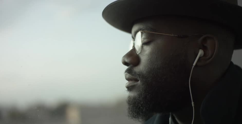 Man with earbuds riding a passenger train