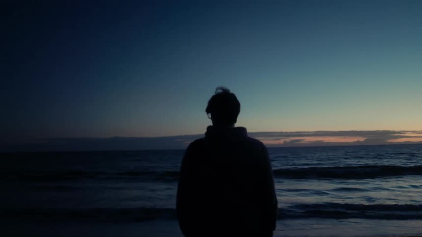 The man watches the sun rise then turns around