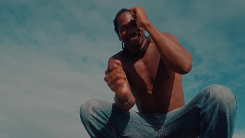 A man is dancing and smiling by the shore