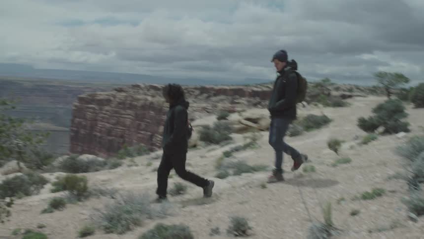 People walking down a sand dune