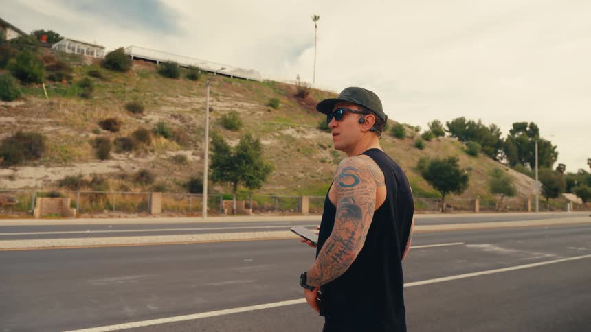 Man standing roadside checking phone