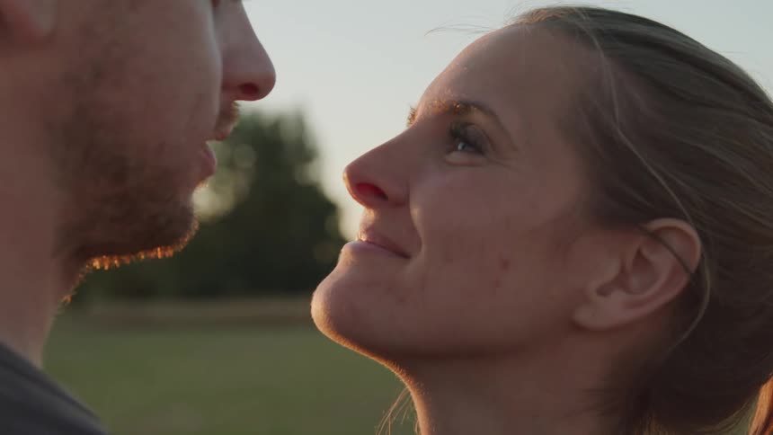 A man gently kisses a womans forehead as she closes her eyes and smiles warmly