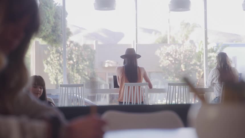 Women walk and sit in the coffee shop