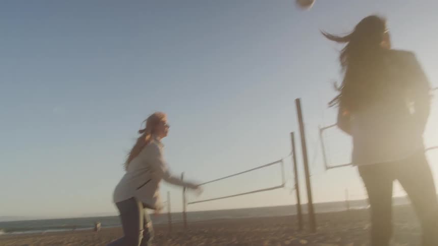 Women on the beach playing volleyball in the sand