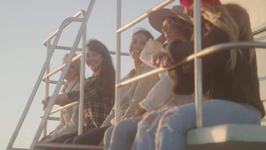 Friends sit on the lifeguard stand together on a windy day