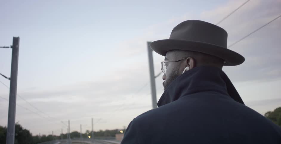Man with a hat looks towards the distance