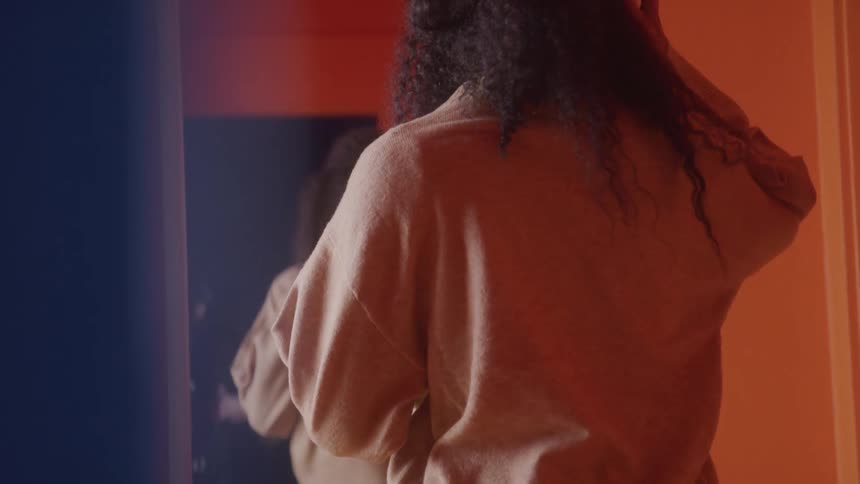 Curly haired woman looking at herself in the mirror