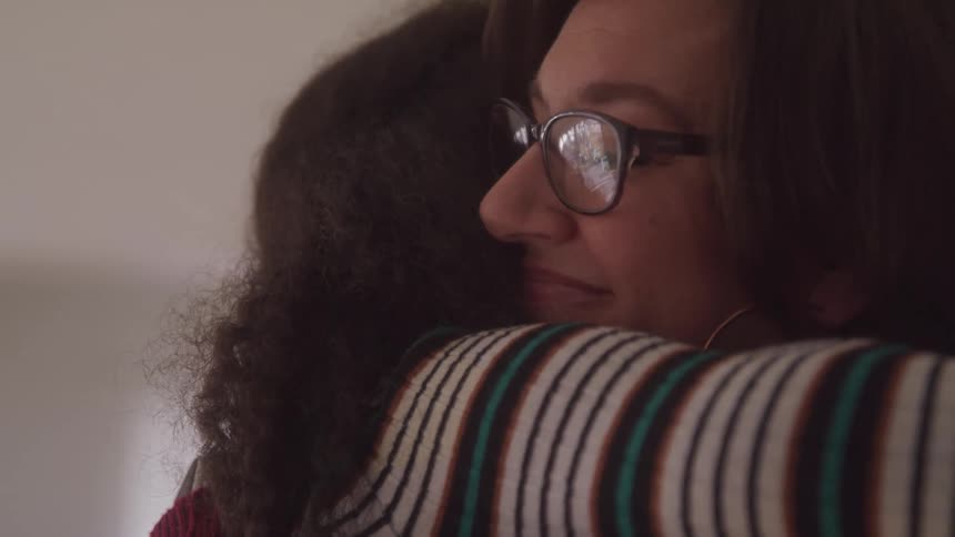 Two women are hugging tight