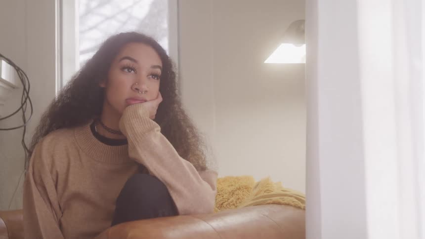A woman looks bored while looking out the window