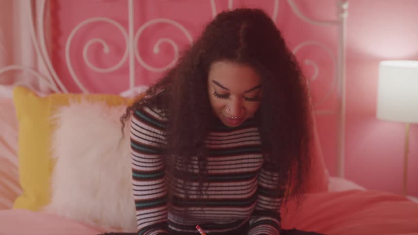 A girl in bed writing