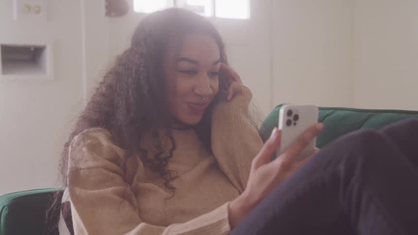 The woman is laughing at her cell phone