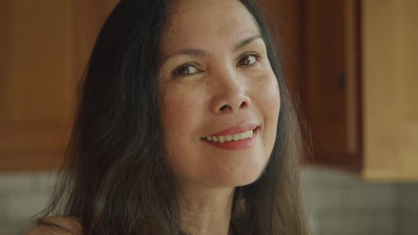 Woman in an indoor space with a smile on her face