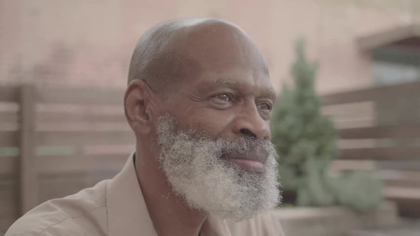 An older man with a happy expression looking forward