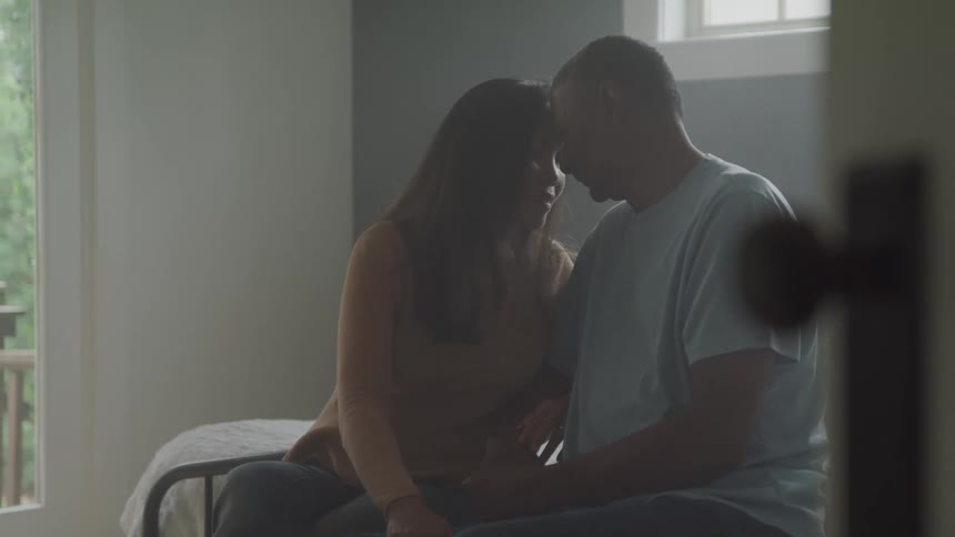 Couple sitting on a bed in a romantic moment