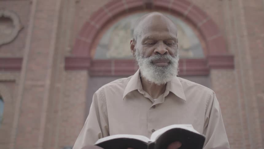 White bearded man reading a book