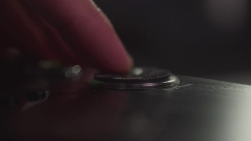 A finger rubbing on a button in a circular motion