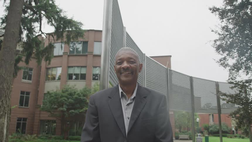 Man in grey blazer with happy facial expression in outdoor setting
