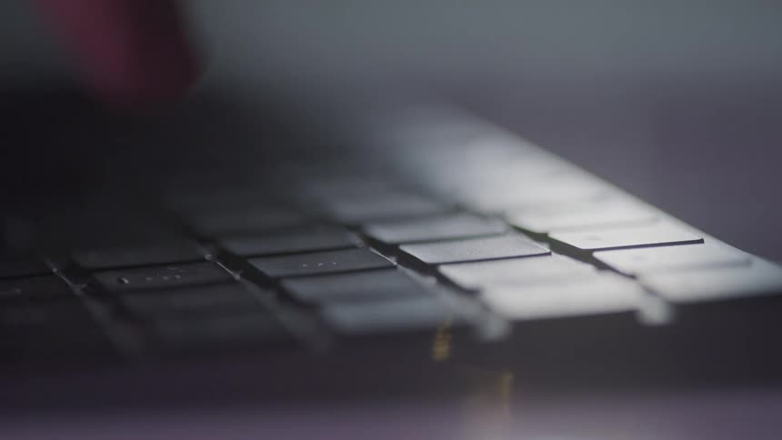 A finger taps at a keyboard