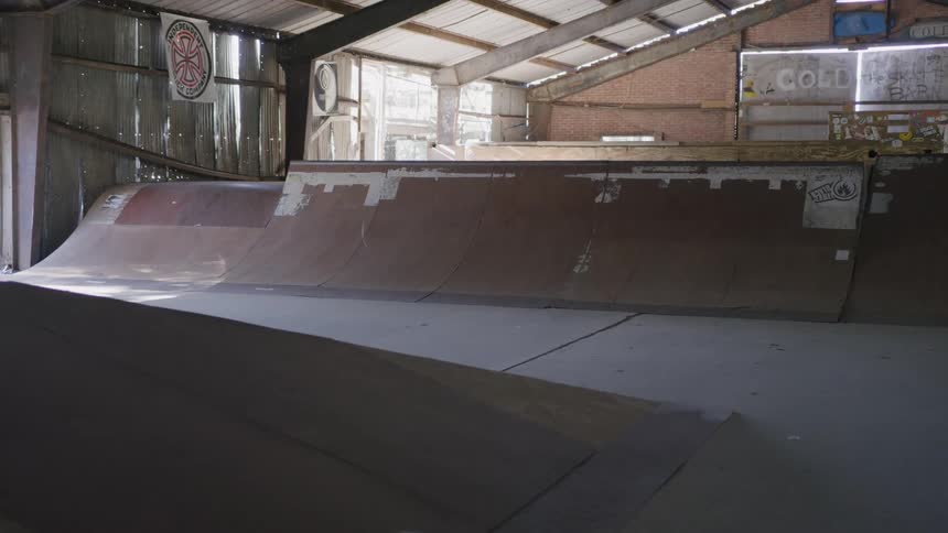Indoor skatepark with wooden ramps under soft lighting