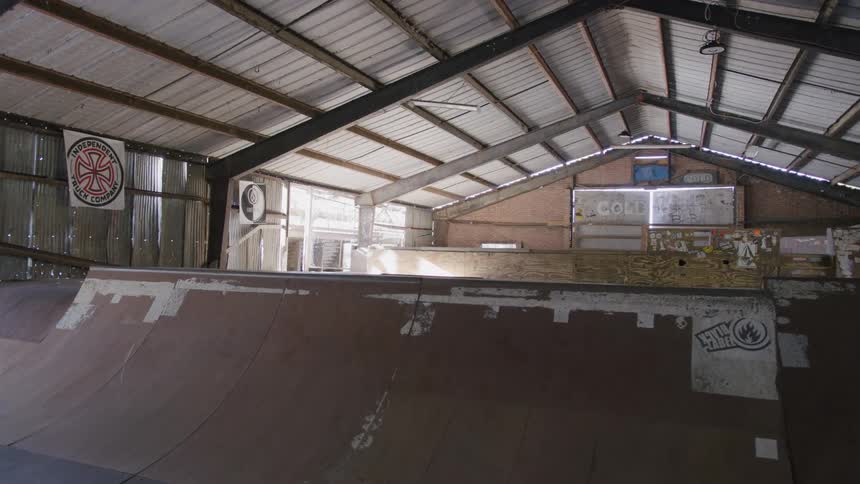 An empty skate barn with a series of skate bowls