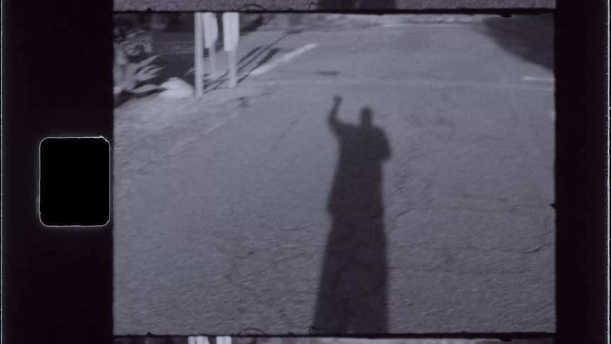 The persons shadow on the road is waving
