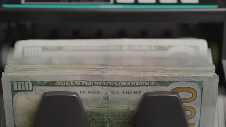 Close up of an electronic paper bill counter counting multiple dollar notes