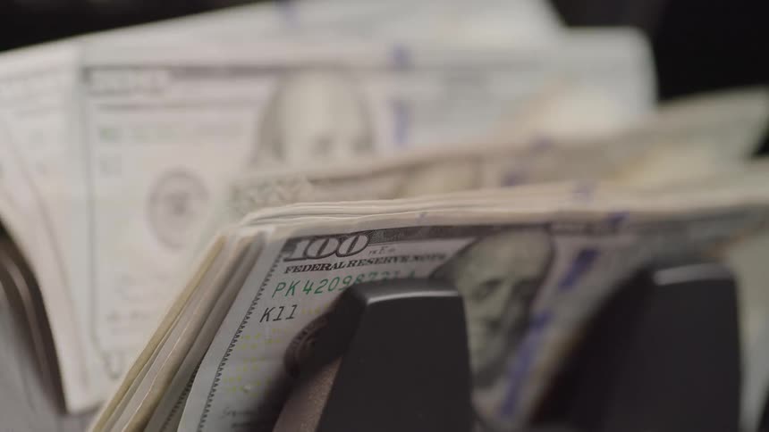Hundred dollar bills being counted on a counting machine