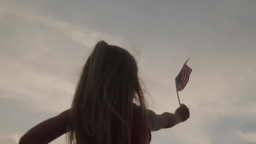 Little blonde girl holding a small american flag