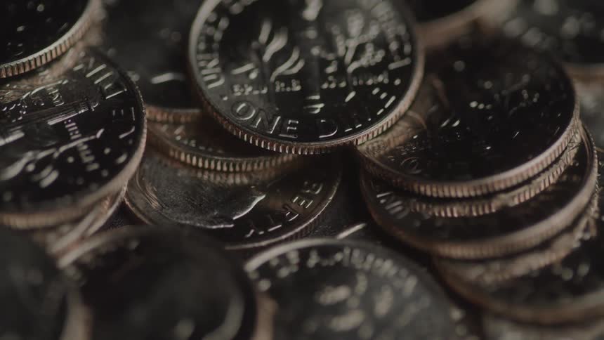 A tight close up of shiny u s coins stacked and overlapping each other