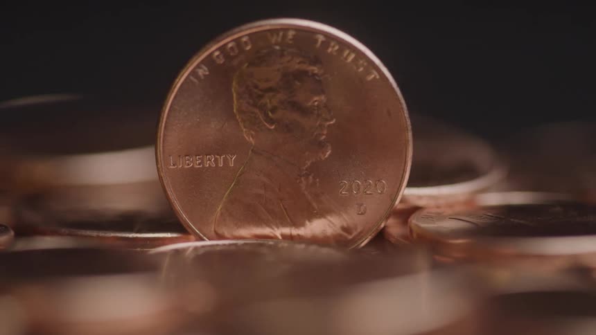 Close up of a coin standing vertically on a surface amongst other similar coins