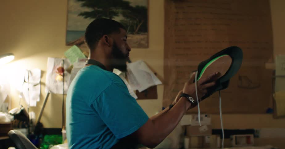 A black man making shoe inside a workshop