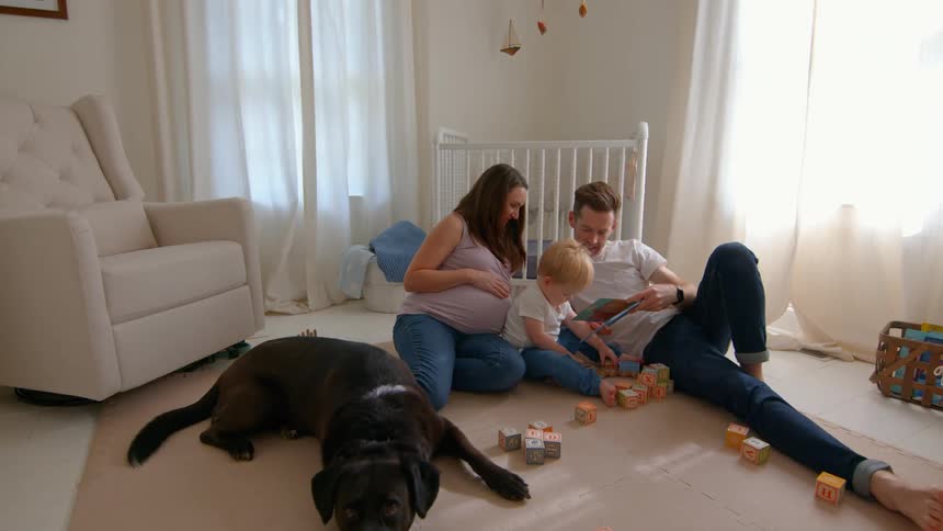 Father is reading to his son on the floor
