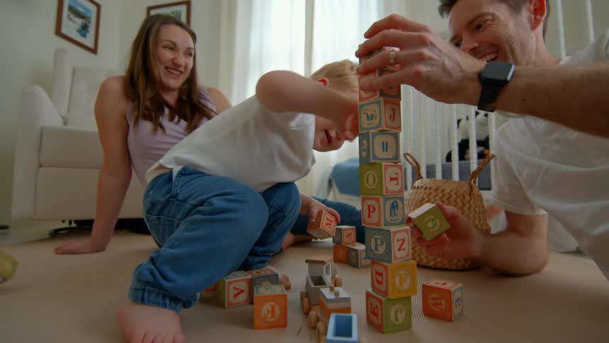 A child topples a stack of blocks
