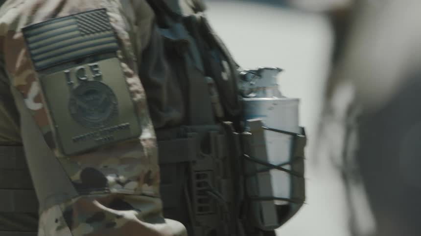 Two law enforcement officers are in a camouflage uniform