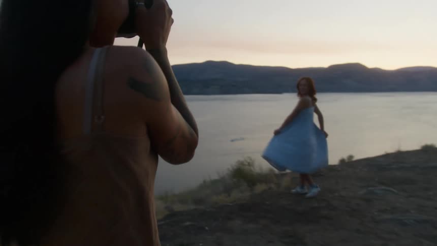 A woman is taking photos of another woman spinning back and forth