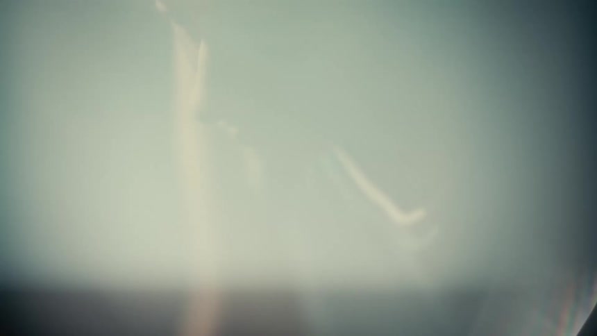 A person wearing a white shirt is partially visible in a dimly lit environment