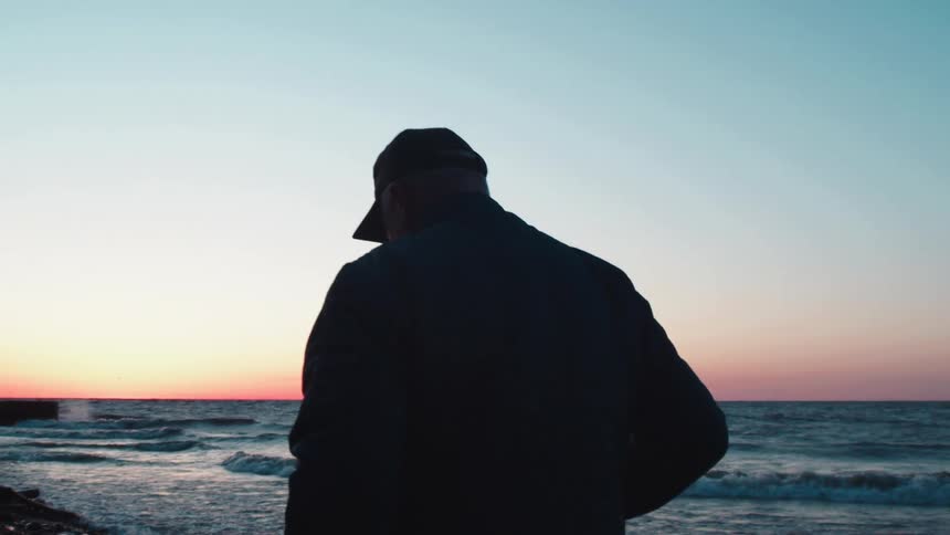Man walking on the beach at sunrise