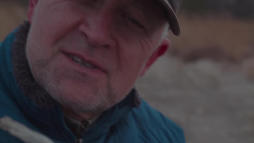 Man in cap holding a piece of wood