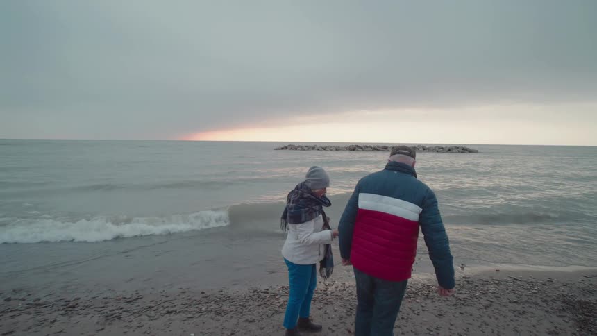 Couple walking on a beach on a cloudy day