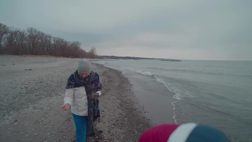 Husband and wife are collecting rocks along the beach