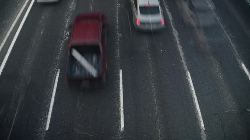 Aerial time lapse of vehicles passing by on a busy freeway