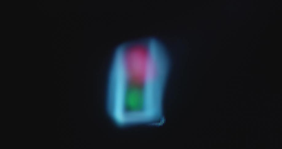 An American or US traffic light animation is displayed on a pixelated RGB screen of a retro tube TV with each color taking turns glowing brightly and flashing as a start or stop symbol or signal